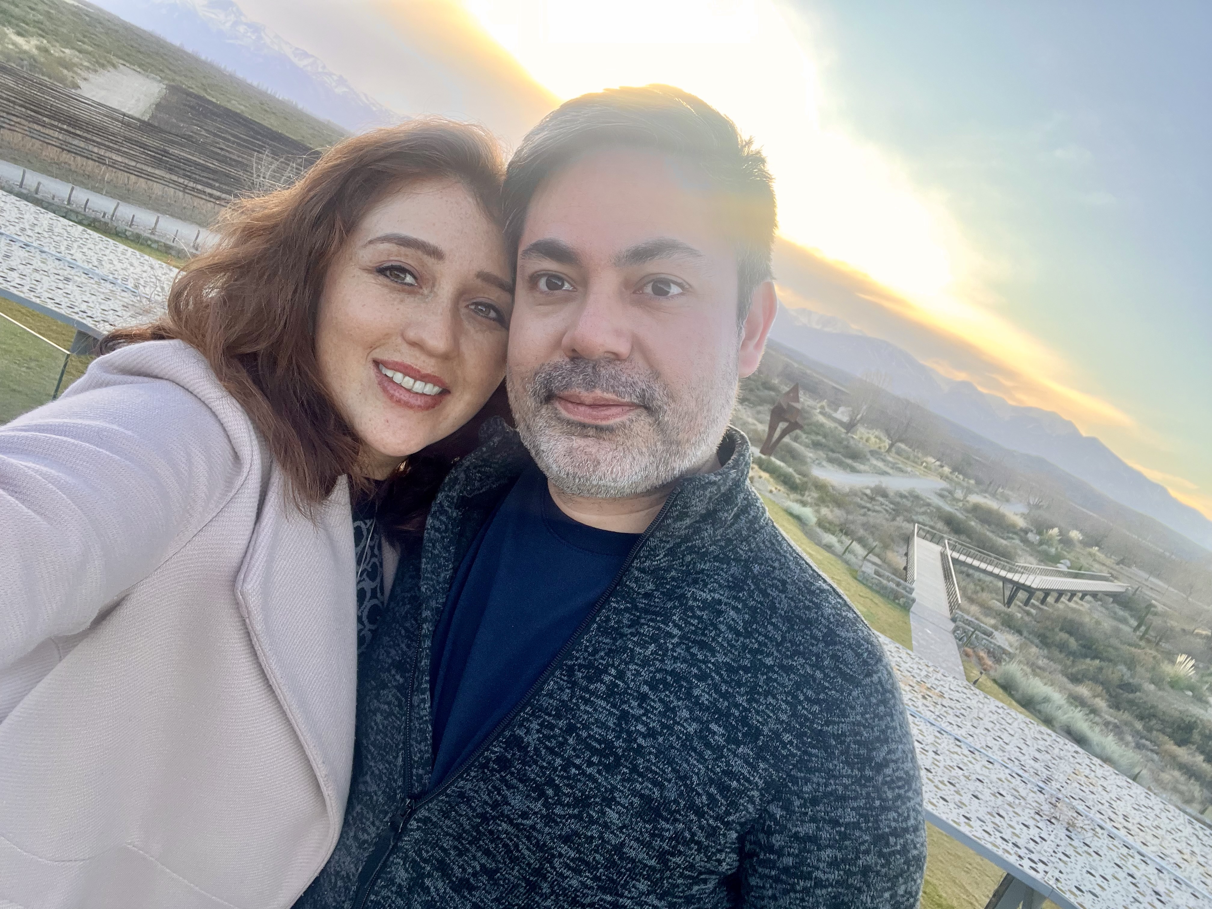 Jasmin y Luis juntos al atardecer en las montañas